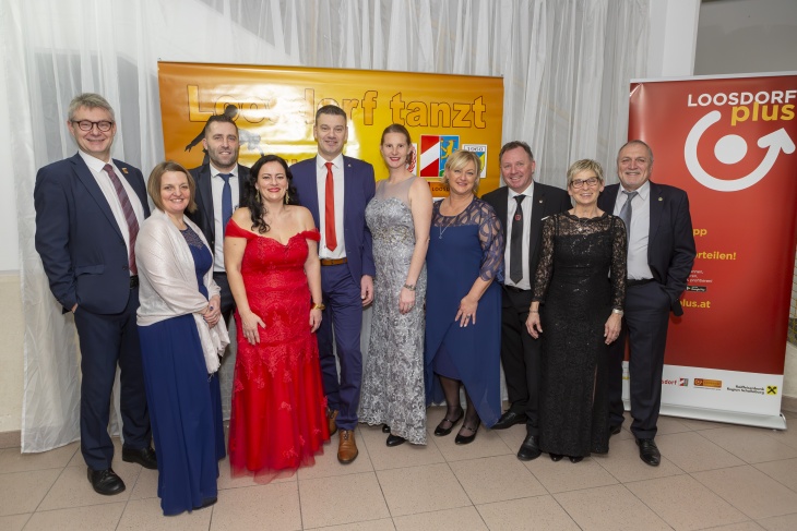 Gruppenbild von beteiligten Veranstaltern vor gro&szlig;em Ball-Plakat