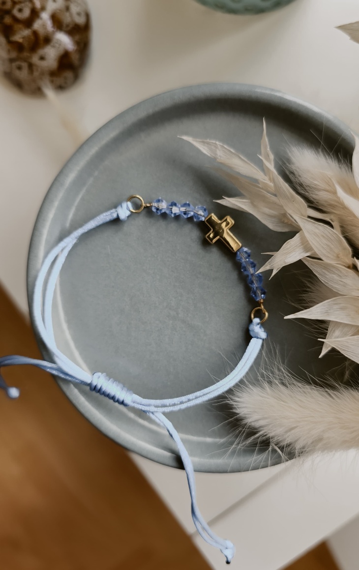 Hellblaues Armband mit goldfarbenem Kreuzanhänger und Kristallperlen – handgefertigtes Geschenk zur Erstkommunion von Elise’s Atelier.