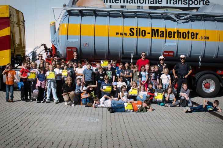 Kindergruppe mit Polizisten vor Silo-Maierhofer LKW in Österreich